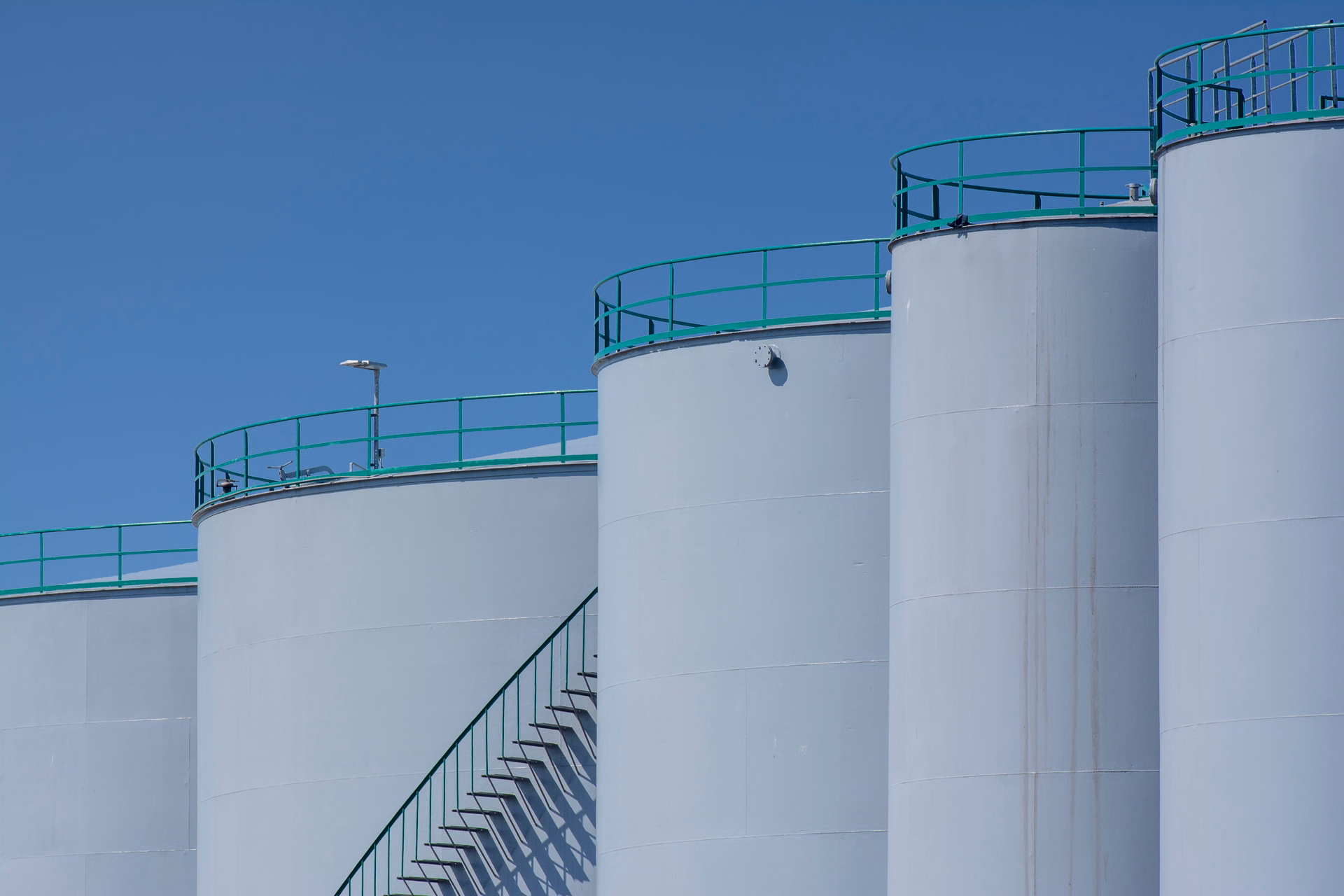 Industrial oil and gas refinery facility at dusk with illuminated process towers